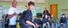 Jörg Jehniche von der Wasserwacht Oschersleben erklärt den Schülern im Gymnasium Oschersleben die  Funktionen einer Taucherausrüstung. Carlo darf sie anprobieren.