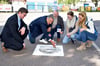 Landtagspräsident Gunnar Schellenberger greift anlässlich des 30-jährigen Jubiläums des Elberadwegs zur Spraydose, um das Logo an der Barbyer Fährstelle auf die Fahrbahn zu sprühen. 