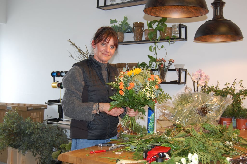 Anne Richter von "Blumenkind" bindet einen Strauß.
