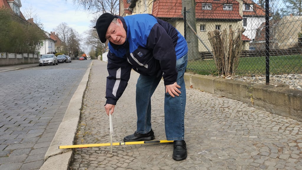Bernhard Haberkorn misst nach: Bis zum 12 Zentiméter tief sind die Löcher in der Mozartstraße.