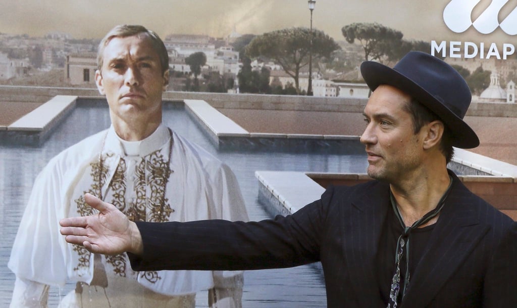 Jude Law vor einem Plakat mit sich als Papst Pius XIII. in der Serie „The Young Pope“. (Archivbild)