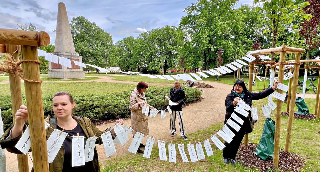 Mitarbeiterinnen der Gedenkstätte, der Stadtverwaltung und des Museums in Bernburg hängten eine Kette mit den Namen aller 470 bekannten NS-Opfer auf dem Martinsplatz auf, die dort in einem Massengrab ihre letzte Ruhe fanden.