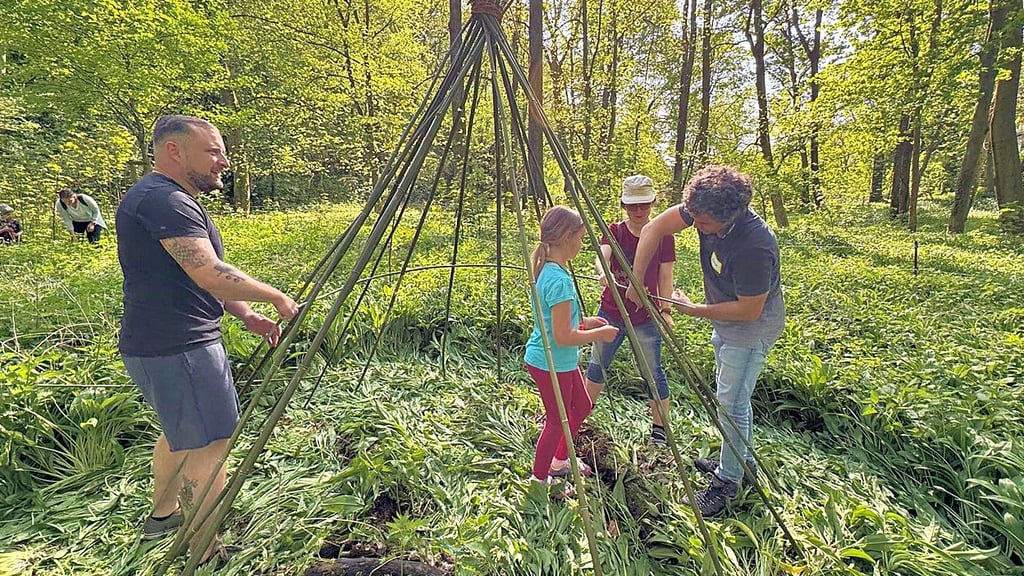 „Waldfreude“-Initiator Alexander Weber (re. im Bild) baut mit Kindern und Eltern gemeinsam ein Tippi für das neue Walderlebniscamp im Tierpark Walbeck.