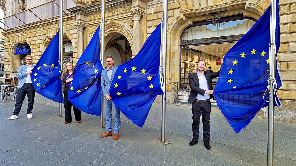 Am Europatag wurden EU-Flaggen vor dem Stadthaus gehisst. V.l.: Tim Kehrwieder (FDP), Catalina Möwes (Volt), OB Alexander Vogt und David Horn.