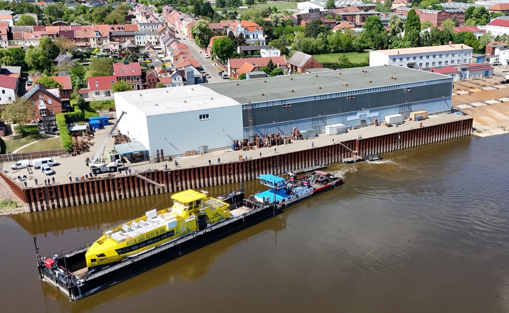Das gelbe Fährschiff - ein Neubau der Tangermünder Schiffbauer - wird "Huckepack" im Transportdock "Jürgen" per Schubverband auf der Elbe gen Norden gebracht.