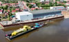 Das gelbe Fährschiff - ein Neubau der Tangermünder Schiffbauer - wird "Huckepack" im Transportdock "Jürgen" per Schubverband auf der Elbe gen Norden gebracht. 