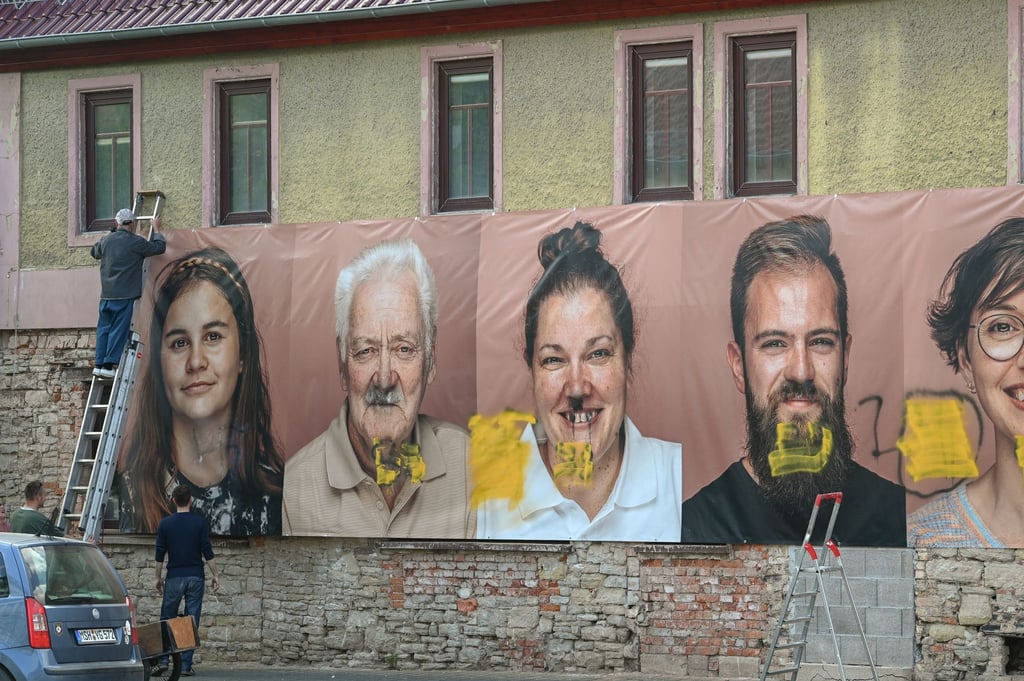Die Planen mit den übergroßen Fotoporträts werden abgenommen.