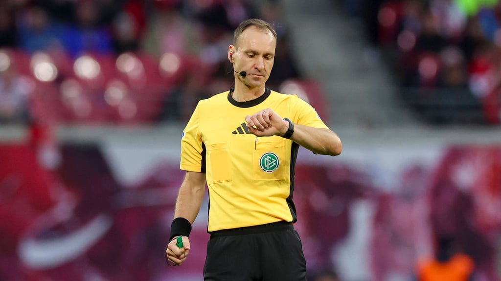 Schiedsrichter Bastian Dankert schaut auf die Uhr.