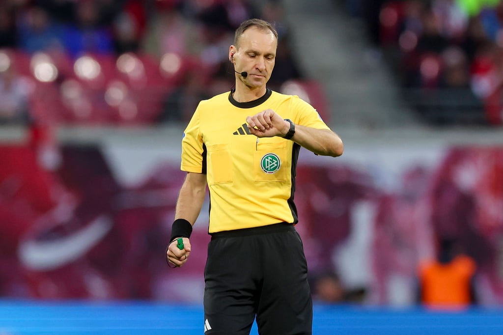 Schiedsrichter Bastian Dankert schaut auf die Uhr.