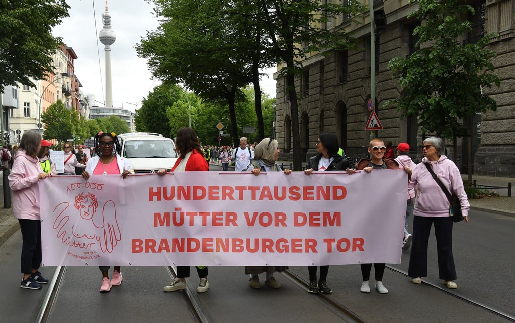 Demonstrantinnen und Demonstranten fordern mehr Unterstützung für Mütter.