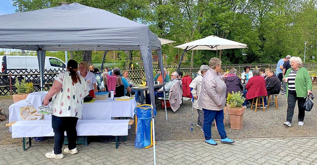 Das Freiluftcafé des Vereins ist gut besucht. Am Stand vorn werden Waffeln gebacken.