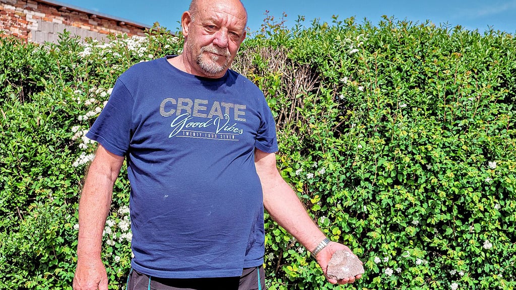 „Solche Steine fliegen hier jeden Tag bis zur Hecke“, sagt Uwe Arndt und zeigt einen faustgroßen Stein, den er zuvor vom Grünstreifen vor seinem Grundstück in der Schulstraße in Lübs aufgesammelt hat.
