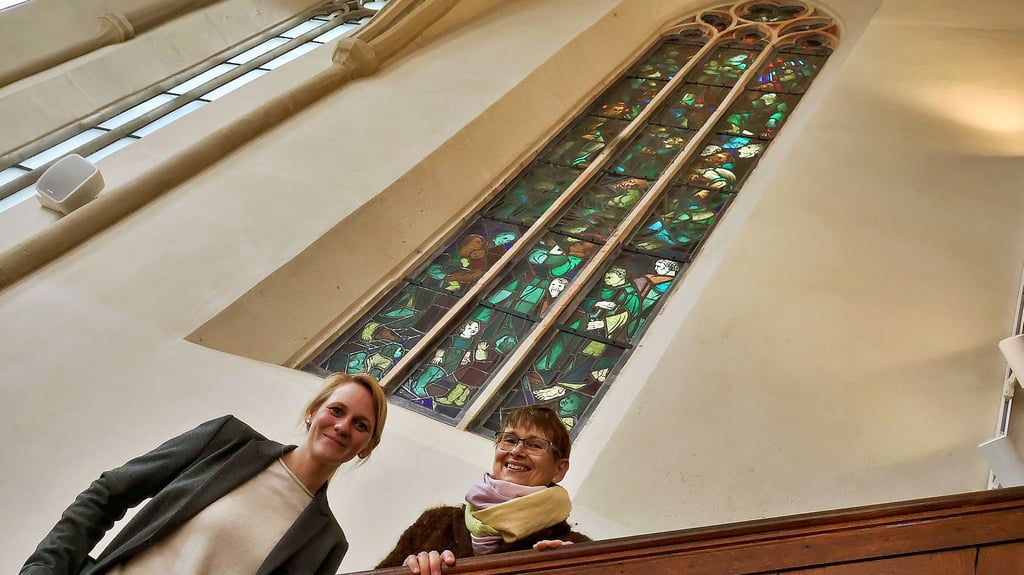 Die Eisleber Pfarrerinnen Iris Hellmich (rechts) und Laura-Christin Krannich freuen sich über das restaurierte Heilsfenster in der Nicolaikirche.