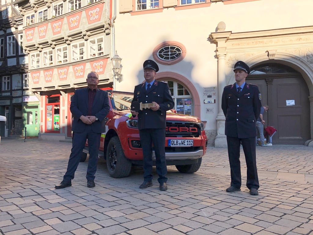 Freude über das neue Fahrzeug, für das Oberbürgermeister Frank Ruch den symbolischen Schlüssel an den stellvertretenden Stadtwehrleiter, Sebastian Petrusch, übergeben hat, der ihn dann an den stellvertretenden Ortswehrleiter, Tim Kunath, weiterreicht (v. l.).
