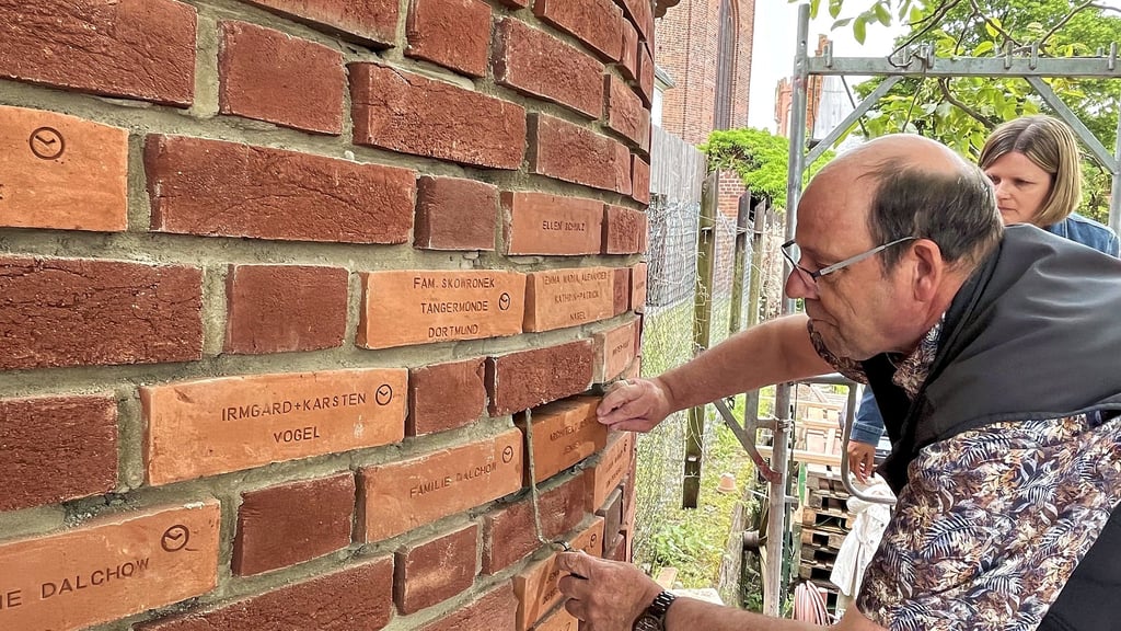 Jörg Jensen setzt, assistiert von Ariane Günzel, den letzten Stifterstein in die Stadtmauer zwischen Elb- und Pfarrgarten.