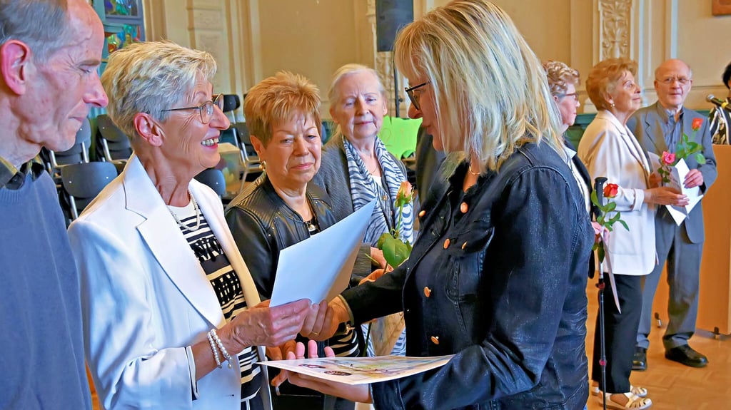 Doreen Steinmetz übergibt ehemaligen Schülern des Abschlussjahrgangs 1965 die Urkunde für das Diamantene Abitur.