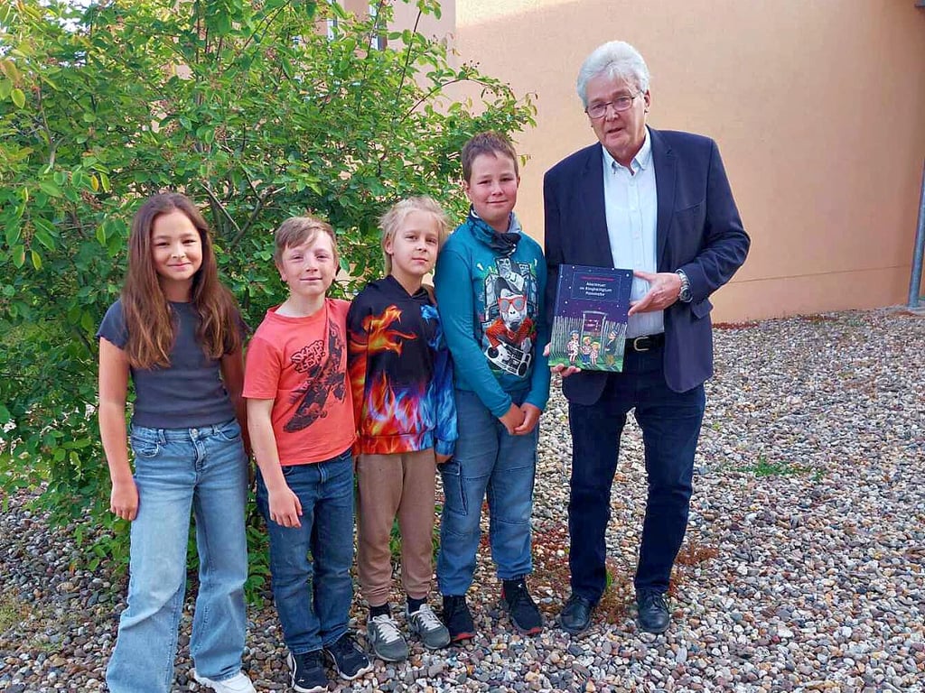 Olaf Busch mit Kindern der Barbyer Grundschule „Am Prinzeßchen“ bei der Buchübergabe.