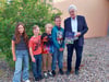 Olaf Busch mit Kindern der Barbyer Grundschule „Am Prinzeßchen“ bei der Buchübergabe. 