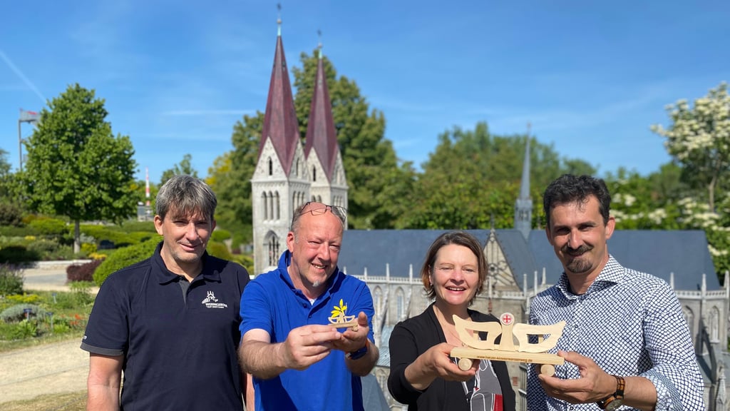 Wer sie entdecken will, muss schon ganz genau hinschauen (von links): Jens Friedrich (Wernigerode Tourismus GmbH), Modellbauer Olaf Keiner, Melanie Krilleke (Harzer Tourismusverband) und Wernigerodes Tourismuschef Andreas Meling präsentieren Mini-Engelsbänke, die ab sofort im Miniaturenpark zu entdecken sind.