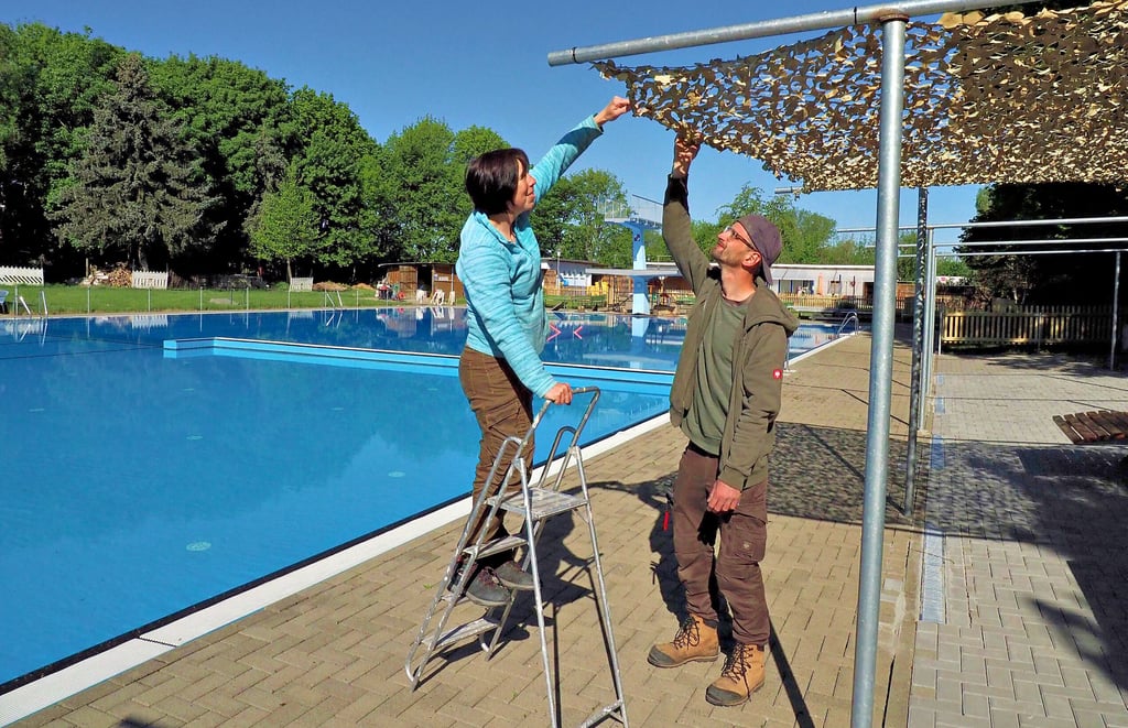 Das Wasserbecken ist gefüllt, aber es sind vor dem Saisonstart noch tausend andere kleine Dinge zu tun für Jenny Uhde und Florian Bänecke. Wie hier das Tarnnetz als Sonnenschutz für den Bereich der Liegen festzuzurren.
