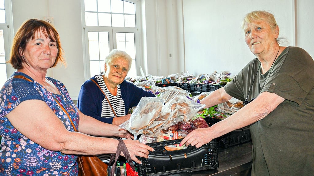 Die Zerbster Tafelleiterin Ute van Tulden (r.) reicht Bärbel Brentrop eine der Lebensmittelkisten. Wie Viola Bensch (M.) kommt sie regelmäßig zur Tafel. Dass nun deren Schließung droht, bereitet beiden Sorge.