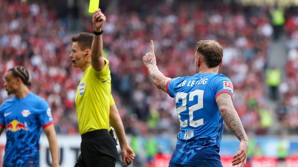 Daniel Siebert zeigt RB-Profi David Raum die gelbe Karte, Raum sieht es anders.