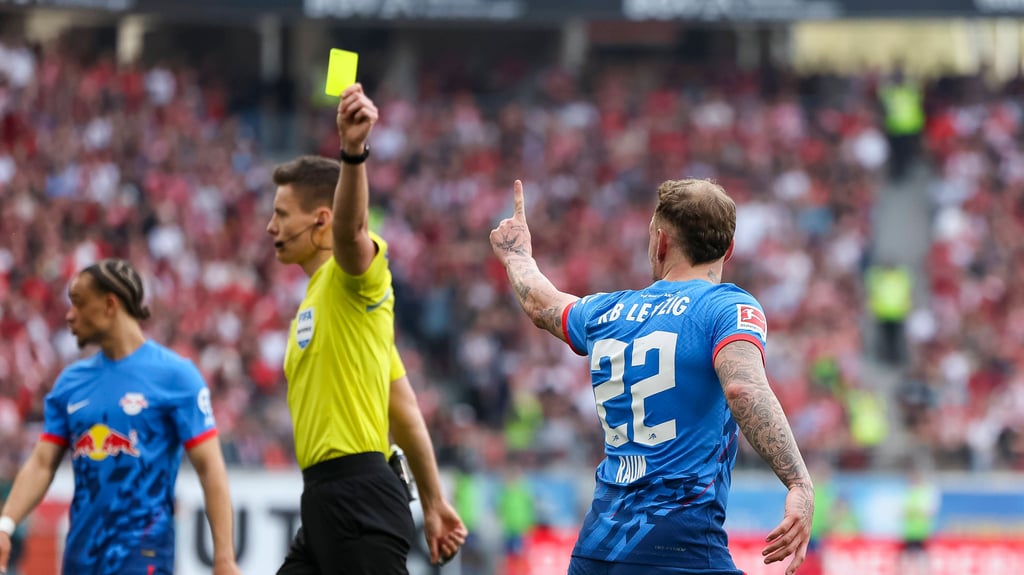 Daniel Siebert zeigt RB-Profi David Raum die gelbe Karte, Raum sieht es anders.