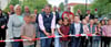 Bürgermeister Sven Hause (M.) zerschneidet hier das Band bei der offiziellen Eröffnung des neuen Calbenser Radweges im Beisein von Hortkindern der nahen Grundschule, einigen Stadträten und Mitarbeitern der beauftragten Baufirmen. 