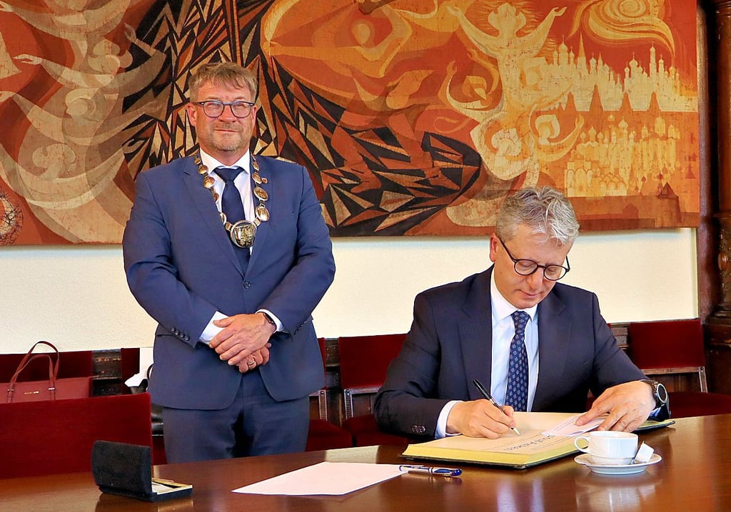 Yusuf Arikan (r.) trägt sich in das Ehrenbuch der Stadt ein.