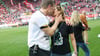 Schiedsrichter Felix Brych (l) küsst seine Ehefrau Andrea Brych-Birgmair nach seinem letzten Bundesligaeinsatz auf dem Rasen.