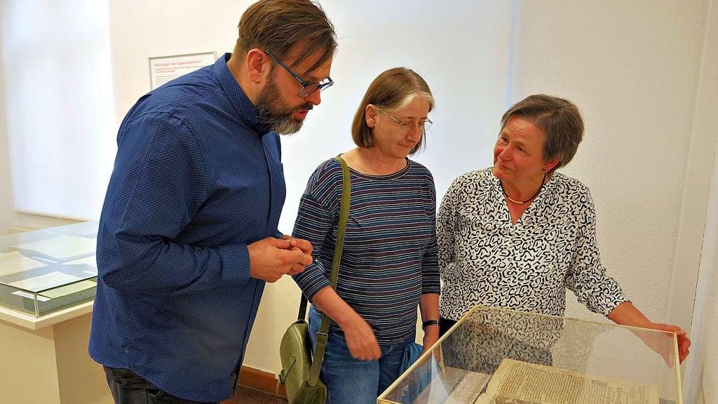 Die Museumsleiter Florian Fischer (Osterburg) und Antje Reichel (Havelberg) betrachten mit der Historikerin Corrie Leitz (von links) die Logenbibel von 1693. Zu sehen in der Ausstellung „NS-Raubgut oder legales Eigentum? “ im Altmärkischen Museum in Stendal.