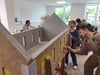 Jaqueline Mämecke und Nicole Horvath (von rechts) aus der Holzwerkstatt der Oskar-Kämmer-Schule Wernigerode, tupfen Farbe auf das Holzmodell der Kirchenruine Hüttenrode, um dem historischen Vorbild so nah wie möglich zu kommen. Das Modell soll der große Blickfang des Harzfestes und kommender Veranstaltungen in Hüttenrode werden.