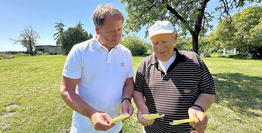 Altenburgs Ortsbürgermeister Frank Effenberger (links) und Heimatfreund Adolf Donath schauen sich alte Fotografien ihres Heimatortes an.