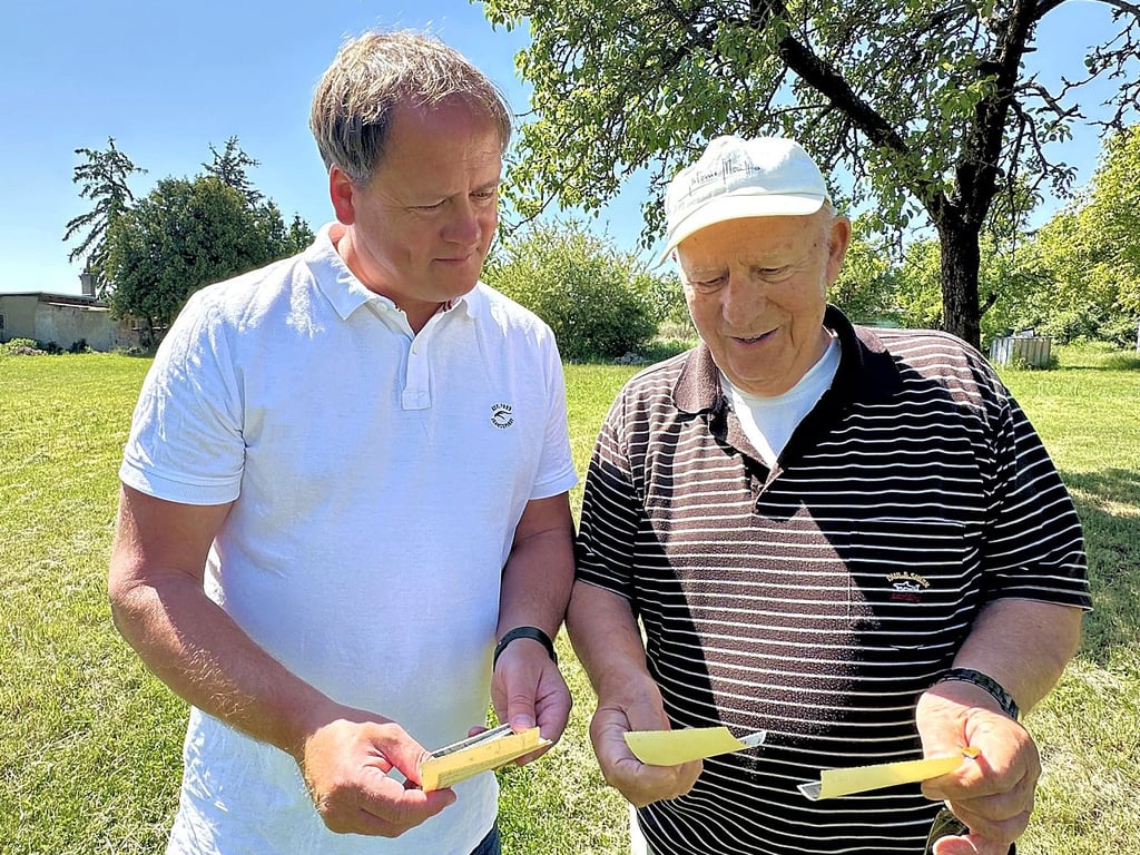 Altenburgs Ortsbürgermeister Frank Effenberger (links) und Heimatfreund Adolf Donath schauen sich alte Fotografien ihres Heimatortes an.