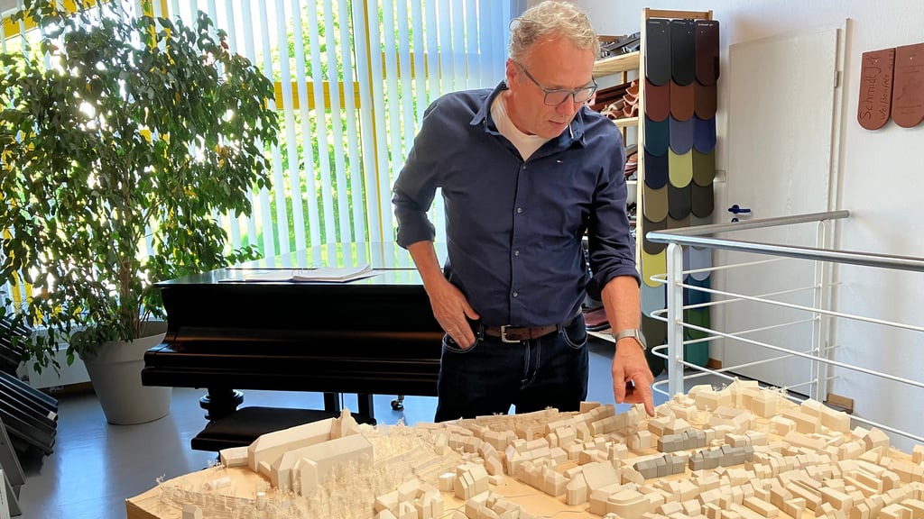 Dachdeckermeister Jens-Norbert Schmidt steht an einem maßstabsgetreuen Modell der Weißenfelser Altstadt.