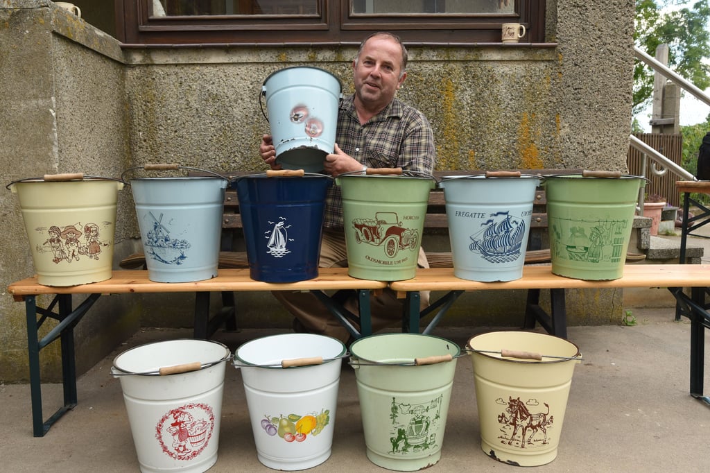 Reinhard Höfflin aus Sachsendorf sammelt alte Hausgeräte. Dazu gehören auch emaillierte Eimer, die allesamt mit einem Aufdruck verziert sind. Einige von ihnen stammen aus DDR-Zeiten und wurden im VEB Eisenhüttenwerk Thale produziert, wo auch die verzinkten Mülltonnen herkamen.