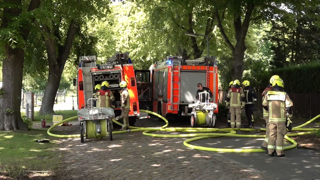 Feuerwehrleute sind bei einem Brand in einem Einfamilienhaus in Berlin-Staaken im Einsatz.
