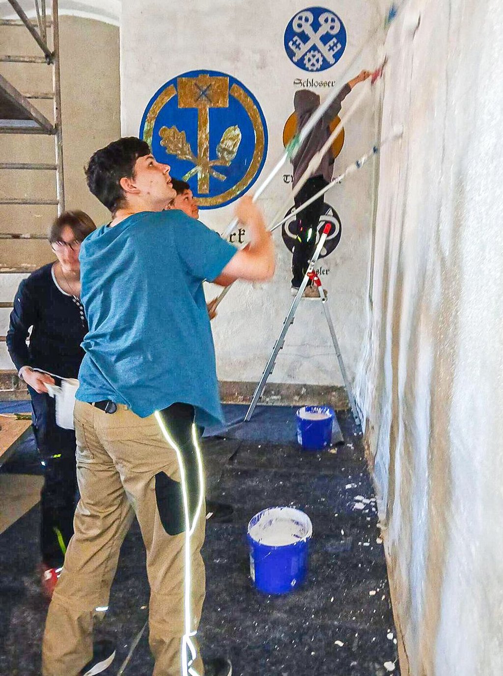 Bei den Malerarbeiten in der Reithalle werden die Schüler professionell angeleitet.