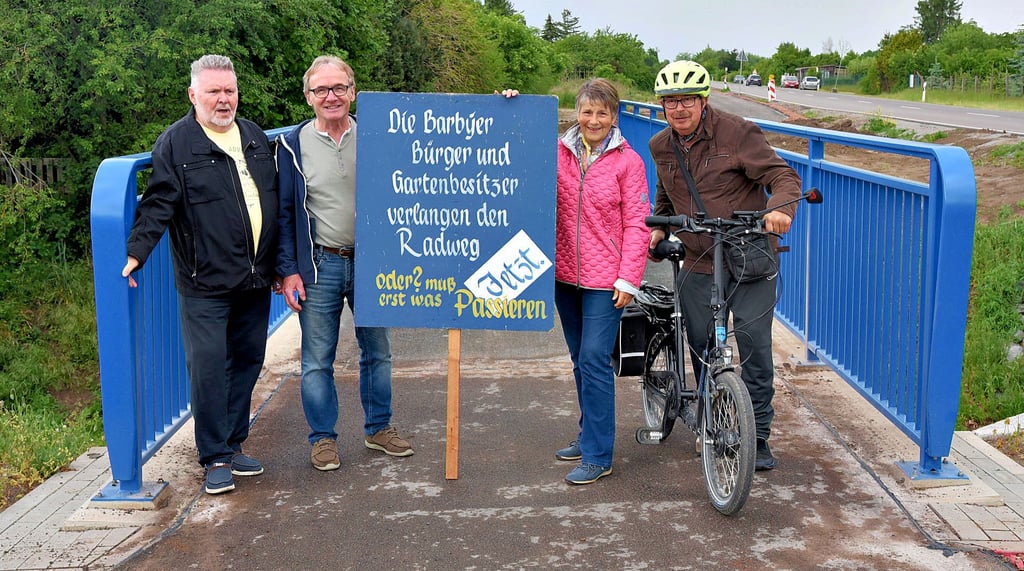 Alles wird gut. Vier Kämpfer für den Radweg von Barby nach Pömmelte trafen sich an der neuen Landgrabenbrücke mit einem „historischen“ Plakat. Von links Rainer Bittersmann, Frank Bläsing, Karin Knopf und Werner Zenker. Der neue Radweg soll einen Tag vor Himmelfahrt offiziell frei gegeben werden.