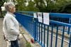 Oberhalb der abgerissenen Fußgängerbrücke auf der Westseite des Schleinufers schaut sich Magdalena Steinberg die ungewöhnliche Traueraktion an.