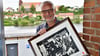 Geschäftsführer Andreas Lewerken auf der Schiffswerft in Havelberg mit einem Bild, das ihn in den  Anfängen auf dem Kiebitzberg in Kuhlhausen zeigt, wo vor 40 Jahren alles mit dem Herstellen von Holzspielzeug begonnen hat. Der Künstler Henry Korwald aus Kamern hat den Holzschnitt nach einem alten Foto angefertigt.