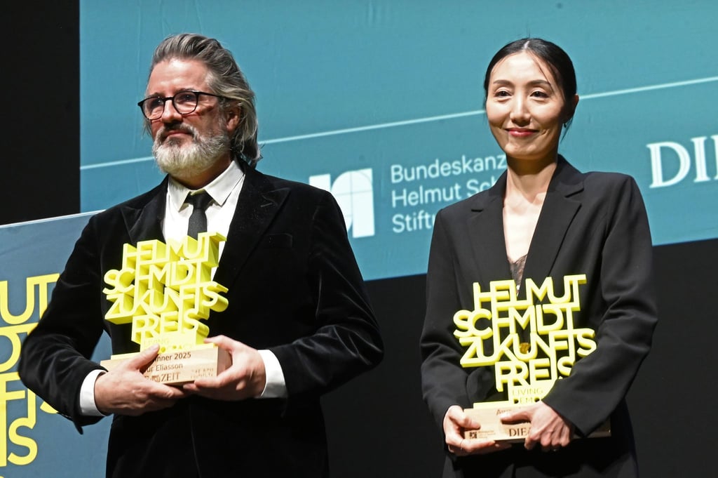 Olafur Eliasson und Hwanhee Hwang stehen mit dem Helmut-Schmidt-Zukunftspreis auf der Bühne im Hamburger Thalia Theater.