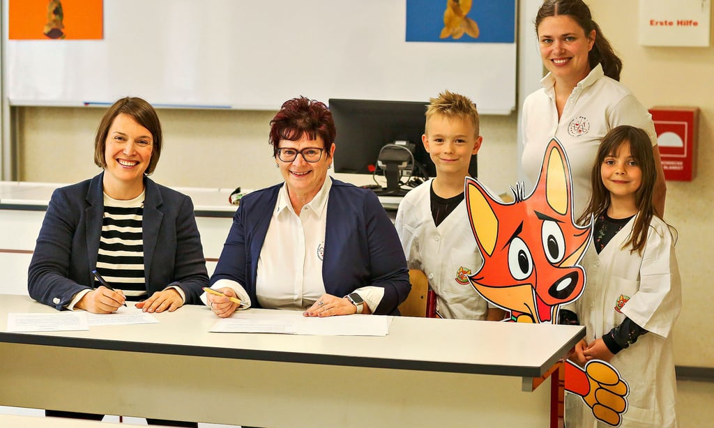 Stephanie Weiner, Annett Dierks, Niklas, Rebekka Gerlach-Schwerdt und Paula posierten mit dem Schulmaskottchen Schlaufuchs bei der Unterzeichnung der Kooperationsvereinbarung.
