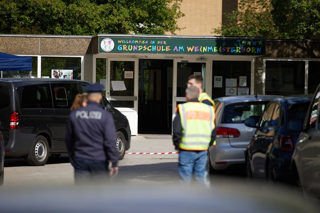 Polizisten stehen vor einer Schule im Berliner Bezirk Spandau, an der es am Vormittag einen möglichen Messerangriff auf einen Schüler gab.