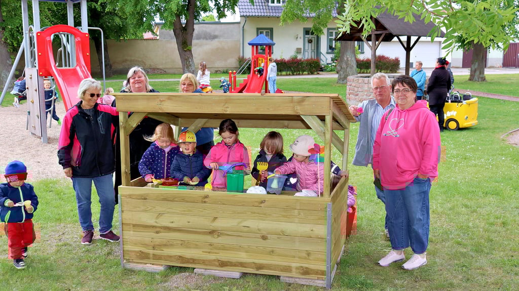 Ortsbürgermeisterin Ines Schleinitz, Madeleine Hoffmann sowie die Kinder mit ihren Erzieherinnen bei der feierlichen Einweihung der Matschküche.
