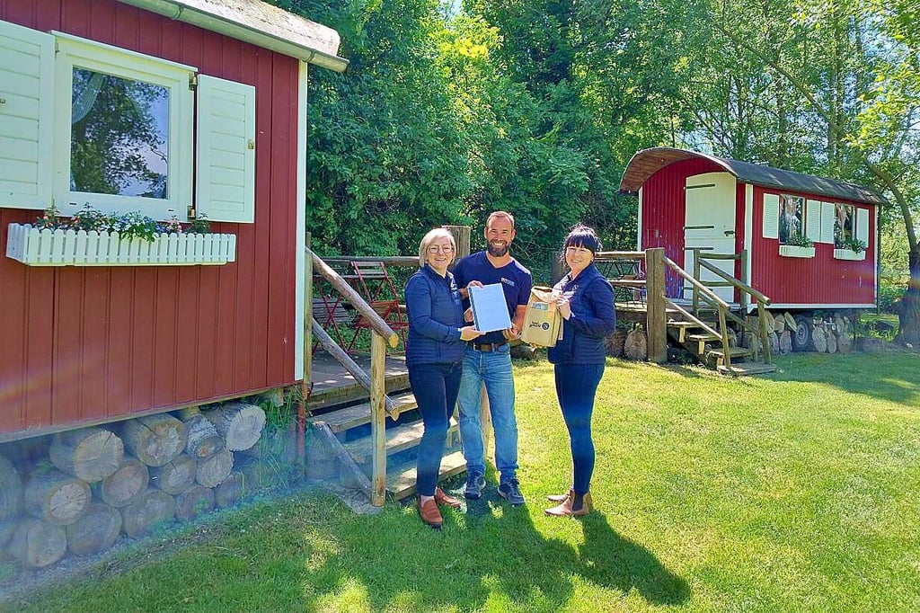 Antje Peiser von Saale-Unstrut Tourismus GmbH (li.) überreicht Jens Bellmann die Auszeichnung. Carolyn Fox von der ABteilung "Produktcheck" gratuliert.