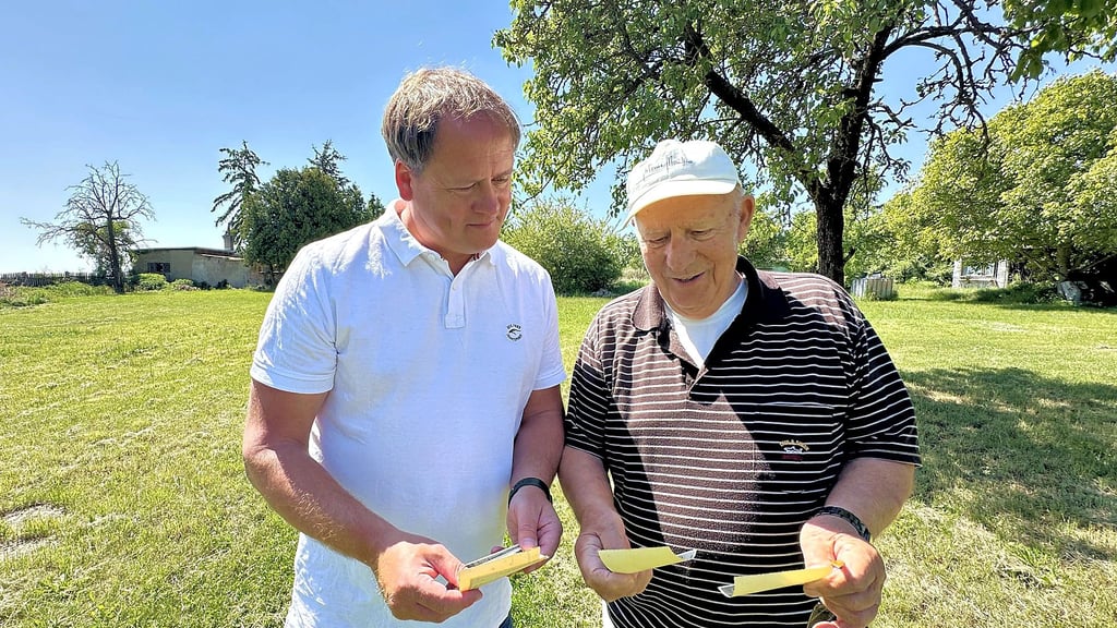 Altenburgs Ortsbürgermeister Frank Effenberger (links) und Heimatfreund Adolf Donath schauen sich alte Fotografien ihres Heimatortes an.