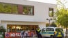 Die Polizei steht vor einer Grundschule im Berliner Bezirk Spandau, während Schüler am Morgen zur Schule kommen.