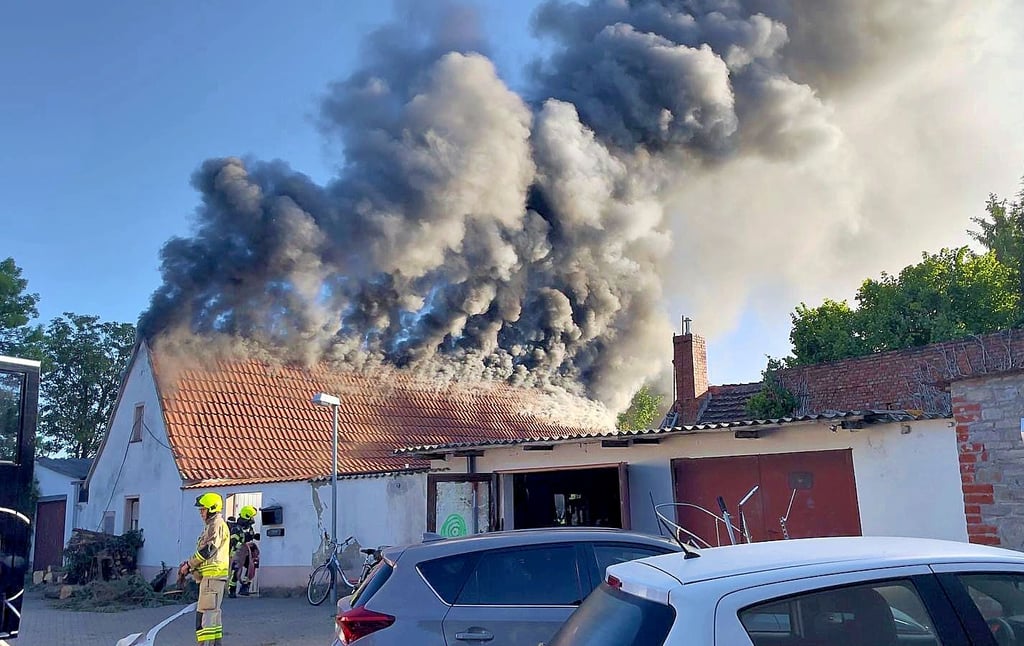 Dunkler Qualm quoll aus dem Dach des Hauses.