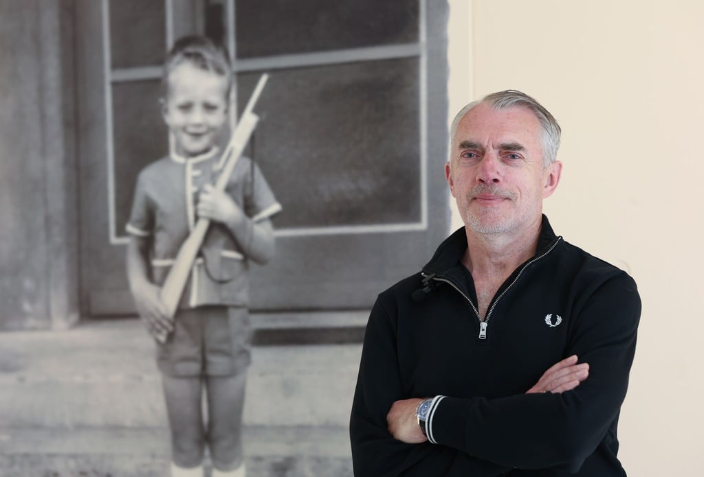 Neo Rauch steht in der „Grafikstiftung Neo Rauch“ in der Ausstellung „Neo – Zeichnungen 1965 bis 1968“ neben einem Kinderportrait.
